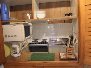 a small kitchen with a stove and a microwave at Appartement La Clusaz, 2 pièces, 6 personnes - FR-1-459-83 in La Clusaz