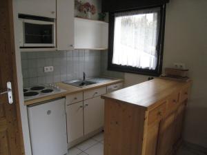 a kitchen with white cabinets and a sink and a window at Studio La Clusaz, 1 pièce, 4 personnes - FR-1-459-85 in La Clusaz