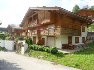 una gran casa de madera con muchas ventanas en Appartement La Clusaz, 3 pièces, 6 personnes - FR-1-459-90 en La Clusaz