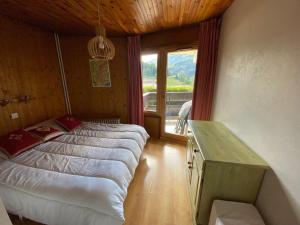 a bedroom with a bed and a desk and a window at Appartement La Clusaz, 2 pièces, 4 personnes - FR-1-459-116 in La Clusaz