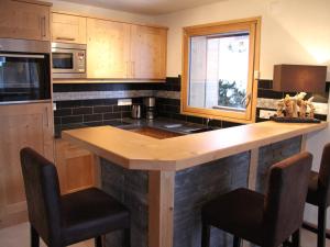 a kitchen with a island with bar stools in it at Appartement La Clusaz, 3 pièces, 6 personnes - FR-1-459-87 in La Clusaz