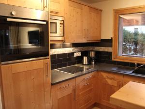 een keuken met houten kasten, een wastafel en een raam bij Appartement La Clusaz, 3 pièces, 6 personnes - FR-1-459-87 in La Clusaz