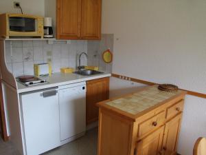 La cuisine est équipée d'un réfrigérateur blanc et d'un évier. dans l'établissement Appartement La Clusaz, 2 pièces, 4 personnes - FR-1-459-92, à La Clusaz