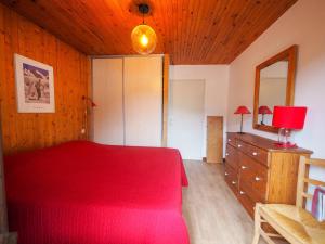 ラ・クリュサにあるAppartement La Clusaz, 2 pièces, 4 personnes - FR-1-459-114のベッドルーム1室(赤いベッド1台、ドレッサー、鏡付)