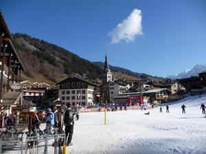 un grupo de personas esquiando en una pista cubierta de nieve en Studio rénové au cœur de La Clusaz, proche pistes et commerces - FR-1-459-115, en La Clusaz
