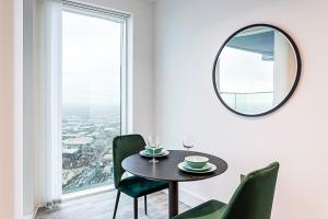 a dining room with a table and chairs and a mirror at Icon Tower Flat VII in London
