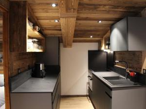 a kitchen with black appliances and wooden ceilings at Appartement La Clusaz, 3 pièces, 6 personnes - FR-1-459-136 in La Clusaz