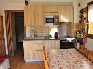 a kitchen with wooden cabinets and a table and a microwave at Appartement Saint-Jean-de-Sixt, 2 pièces, 4 personnes - FR-1-459-165 in Saint-Jean-de-Sixt
