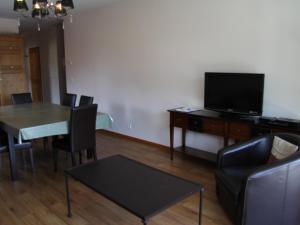 ein Wohnzimmer mit Tisch und Fernseher in der Unterkunft Appartement 3 chambres avec balcon en centre village, proche La Clusaz et Le Grand Bornand - FR-1-459-161 in Saint-Jean-de-Sixt