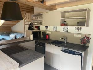 a kitchen with a sink and a couch in a room at Appartement La Clusaz, 4 pièces, 7 personnes - FR-1-459-167 in La Clusaz