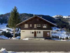 a brown and white house on the side of a road at Appartement La Clusaz, 4 pièces, 6 personnes - FR-1-459-179 in La Clusaz