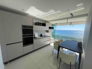 een keuken met een tafel en uitzicht op de oceaan bij Vue mer exceptionnelle, appartement unique de luxe in Cannes
