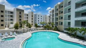 an image of a swimming pool in front of apartment buildings at All-New, Waterfront Condo in Downtown Sarasota! in Sarasota