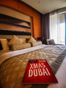 un libro sentado en una cama en una habitación de hotel en OSTAY -Address Dubai Mall - The Residence en Dubái