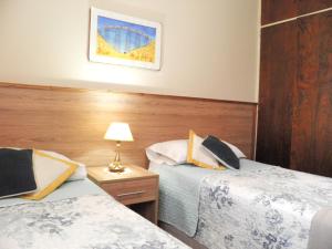 una habitación de hotel con 2 camas y una lámpara en BuenosAires212 en Salta