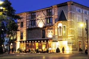 a large brick building with lights in front of it at Hôtel de la Tour in Châtillon-sur-Chalaronne