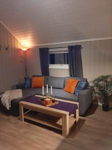 - un salon avec un canapé et une table avec des bougies dans l'établissement Kleines Haus am Fjord, 