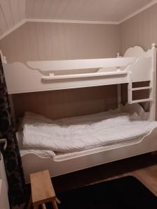 a bunk bed with white bunk beds in a room at Kleines Haus am Fjord 