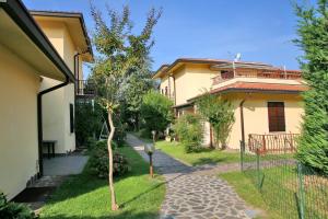 a house with a walkway in front of a yard at Residence Primavera in Bardolino