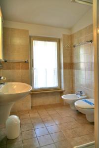 a bathroom with two sinks and a tub and a toilet at Residence Primavera in Bardolino