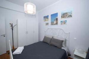 una camera bianca con un letto in una stanza di ΑΙΘΡΑ Suite ad Atene