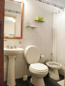 y baño con aseo, lavabo y espejo. en BuenosAires212 en Salta