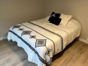 łóżko z czarno-białym kocem w obiekcie Green Bay Stay w mieście Green Bay
