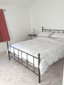 una camera da letto con un letto e un piumone bianco di 'Mill Cottage' Parbold a Parbold