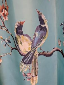 uma pintura de dois pássaros empoleirados num galho de árvore em 'Mill Cottage' Parbold em Parbold