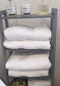 una pila di asciugamani su una mensola in bagno di 'Mill Cottage' Parbold a Parbold