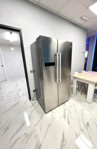 frigorifero in acciaio inossidabile in una stanza con tavolo di Hostel Thirty One 31 a Madrid