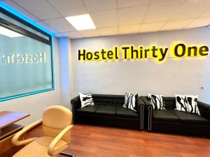 a black couch in a room with a hospital thirty one sign at Hostel Thirty One 31 in Madrid