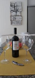 a bottle of wine and two wine glasses on a table at Rosyshome102 in Vecindario