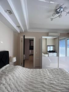 ein Schlafzimmer mit einem großen weißen Bett in einem Zimmer in der Unterkunft Квартира в Алании на берегу Клеопатры in Alanya