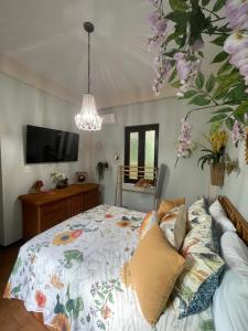 um quarto com uma cama e uma televisão e flores em The Garden Apartment, The Willow Apartment, & The Tropical Apartment at Casa of Essence in Old San Juan em San Juan