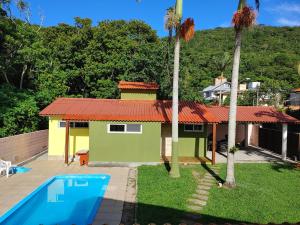 a house with a swimming pool in front of it at LagoMar Hostel in Florianópolis