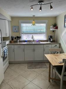 cocina con fregadero, ventana y mesa en Cozy Beach Rental 1B/1B en St Pete Beach