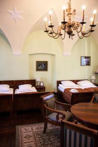 a room with two beds and a table and a chandelier at Zamek w Baranowie Sandomierskim in Baranów Sandomierski