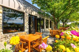 a patio with wooden tables and chairs and flowers at Grand Vista Hotel Grand Junction in Grand Junction