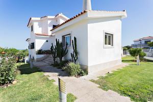 una pequeña casa blanca con un patio de césped en Suite Bela Vista, en Tavira