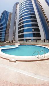 a large swimming pool in front of tall buildings at Superbe studio spacieux et ensoleillé in Ajman 