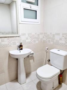 a bathroom with a toilet and a sink at Superbe studio spacieux et ensoleillé in Ajman 
