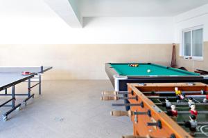 Suite Bela Vista في تافيرا: غرفة مع طاولات بلياردو وكرات تنس الطاولة
