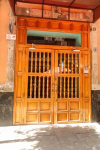 a wooden door of a building with a sign on it at Hotel Juarez in Mexico City