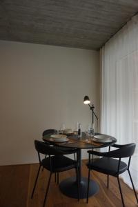 a dining room table with chairs and a table with glasses on it at Schönes Neubau Serviced-Apartment mit Parkplatz in Bruchsal