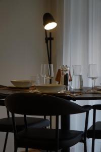 a dining room table with plates and glasses on it at Schönes Neubau Serviced-Apartment mit Parkplatz in Bruchsal +10 photos
