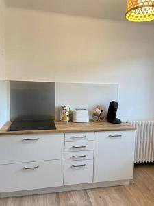 eine Küche mit weißen Schränken und einer Arbeitsplatte in der Unterkunft Vaste Appartement Rénové - Centre Ville in Bourg-en-Bresse