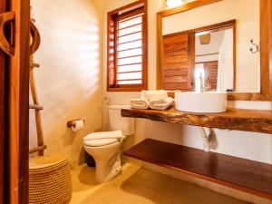 La salle de bains est pourvue d'un lavabo, de toilettes et d'un miroir. dans l'établissement Vilarejo Preá, à Prea