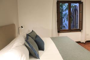Un dormitorio con una cama blanca con almohadas y una ventana en Hotel Del Virrey en Salta