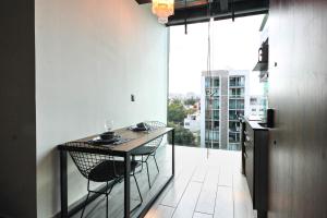 uma cozinha com mesa e cadeiras e uma grande janela em Cómodo y lujoso LOFT 1 em Cidade do México
